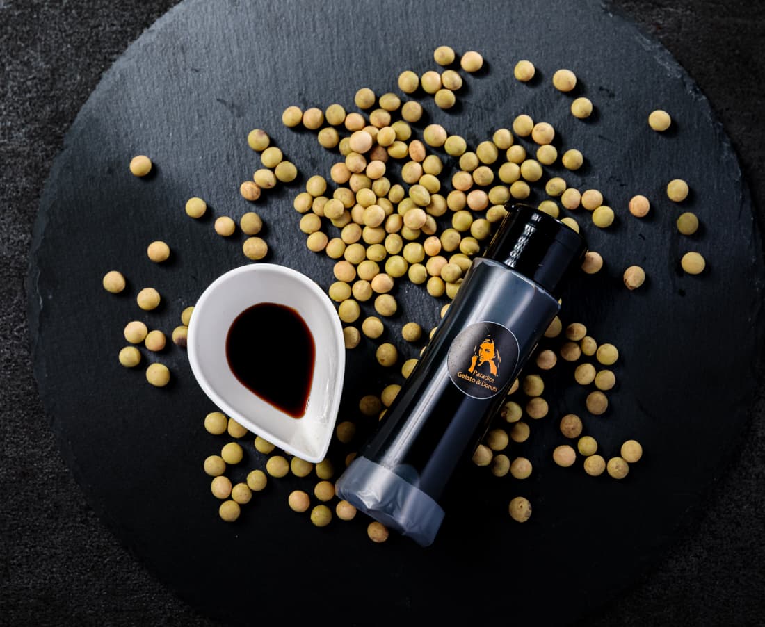 ブランドの醤油パッケージ、小皿に注がれた醤油と大豆が映っている